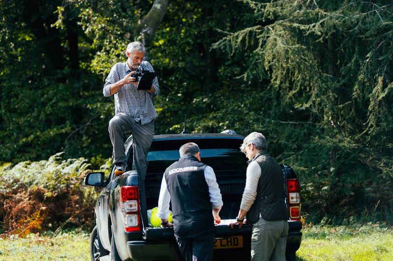 Filming people talking by a vehicle