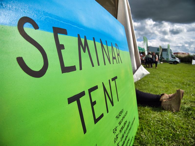 close up of the seminar tent sign listing the speakers