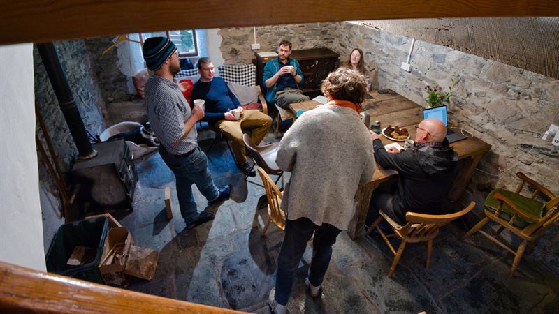directors gathered round a table in the farm house