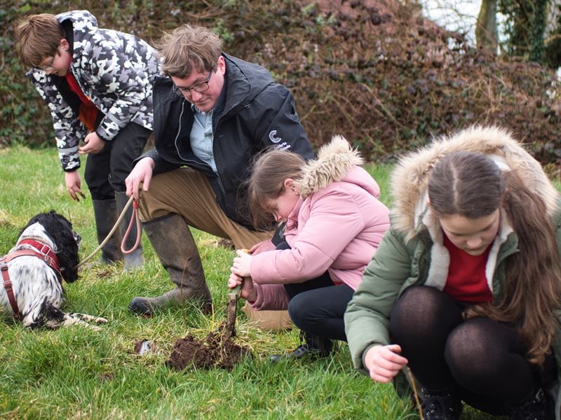 gary planting trees with school children